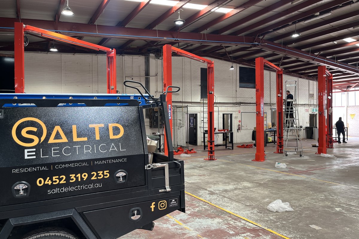 SALTD Electrical ute parked in a mechanical workshop fitted with two-post hoists and high-bay lighting