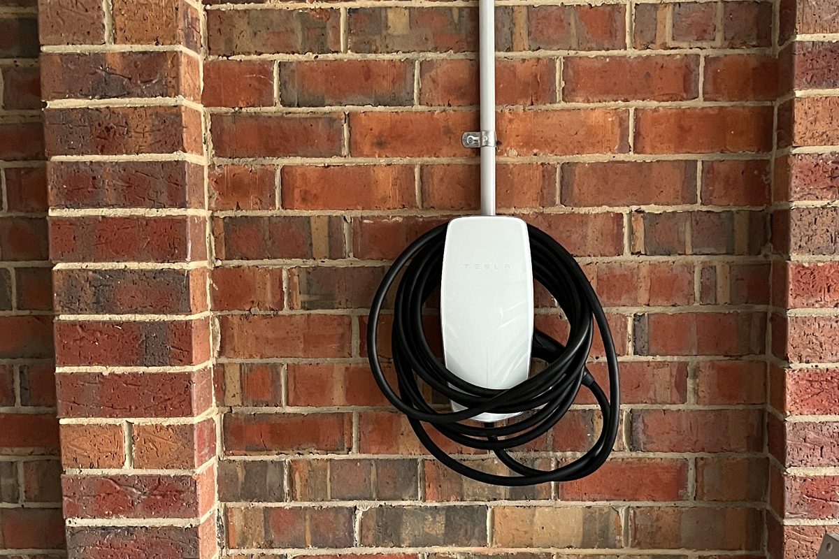 Tesla Wall Connector installed on a garage wall with a tidy dedicated circuit, installed by SALTD Electrical
